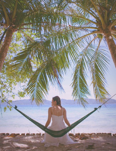 A bride sitting in a hammock on the beach of Amami Oshima